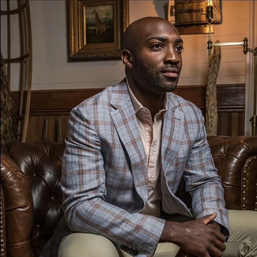 Man in plaid blazer on leather sofa