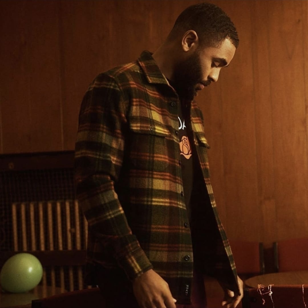 Man in plaid overshirt indoors