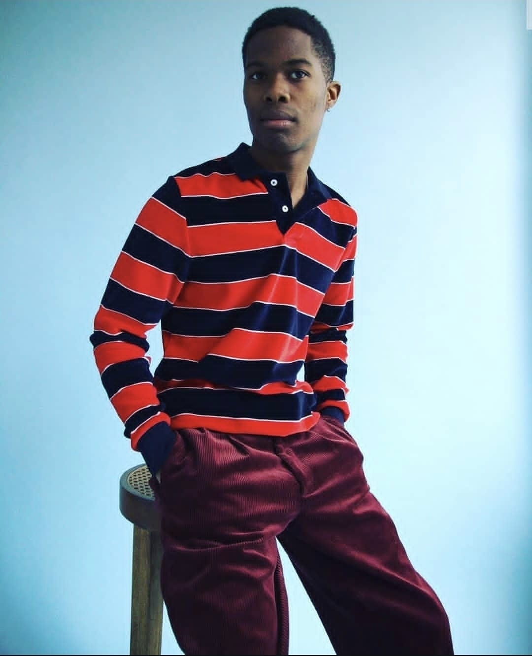 Man in striped polo and burgundy trousers